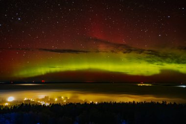 A stunning display of red and green auroras lighting up the night sky, with stars sparkling in the background. The vibrant celestial event creates a mesmerizing, ethereal atmosphere. clipart