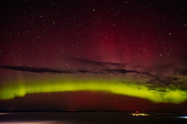 A stunning display of red and green auroras lighting up the night sky, with stars sparkling in the background. The vibrant celestial event creates a mesmerizing, ethereal atmosphere. clipart