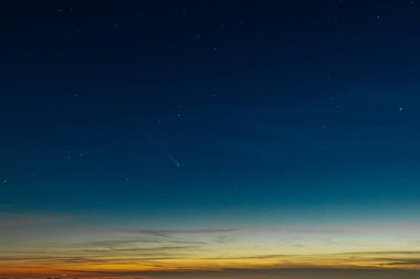 Comet Tsuchinshan-ATLAS shines brightly as it streaks across the night sky with a long glowing tail. The comet is surrounded by numerous faint stars, creating a captivating celestial scene against clipart