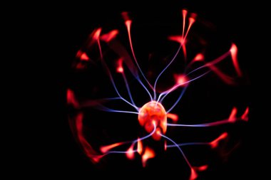 Çekirdeğinden, karanlık bir arkaplana doğru yayılan kırmızı ve mavi elektrik yayı ile parlayan bir plazma topu, canlı ve enerjik bir görüntü oluşturur..