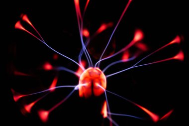 Çekirdeğinden, karanlık bir arkaplana doğru yayılan kırmızı ve mavi elektrik yayı ile parlayan bir plazma topu, canlı ve enerjik bir görüntü oluşturur..