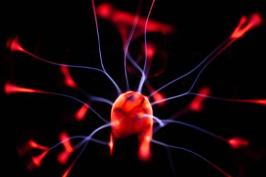 Çekirdeğinden, karanlık bir arkaplana doğru yayılan kırmızı ve mavi elektrik yayı ile parlayan bir plazma topu, canlı ve enerjik bir görüntü oluşturur..