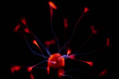 Çekirdeğinden, karanlık bir arkaplana doğru yayılan kırmızı ve mavi elektrik yayı ile parlayan bir plazma topu, canlı ve enerjik bir görüntü oluşturur..