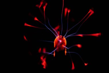 Çekirdeğinden, karanlık bir arkaplana doğru yayılan kırmızı ve mavi elektrik yayı ile parlayan bir plazma topu, canlı ve enerjik bir görüntü oluşturur..