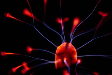 Çekirdeğinden, karanlık bir arkaplana doğru yayılan kırmızı ve mavi elektrik yayı ile parlayan bir plazma topu, canlı ve enerjik bir görüntü oluşturur..