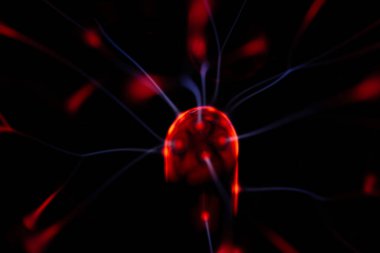 Çekirdeğinden, karanlık bir arkaplana doğru yayılan kırmızı ve mavi elektrik yayı ile parlayan bir plazma topu, canlı ve enerjik bir görüntü oluşturur..