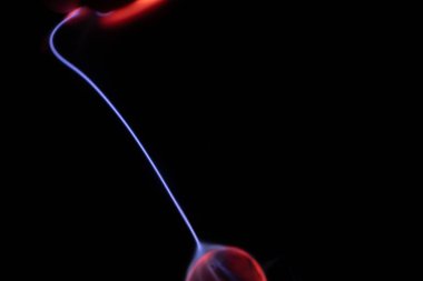 Kırmızı ve mavi enerji yayı ile parlayan bir plazma topu koyu bir arkaplana yayılarak canlı ve heyecan verici bir görsel efekt yaratır.