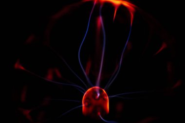 Kırmızı ve mavi enerji yayı ile parlayan bir plazma topu koyu bir arkaplana yayılarak canlı ve heyecan verici bir görsel efekt yaratır.