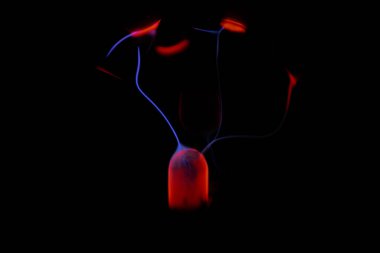 Kırmızı ve mavi enerji yayı ile parlayan bir plazma topu koyu bir arkaplana yayılarak canlı ve heyecan verici bir görsel efekt yaratır.