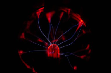 Kırmızı ve mavi enerji yayı ile parlayan bir plazma topu koyu bir arkaplana yayılarak canlı ve heyecan verici bir görsel efekt yaratır.