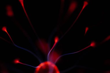 Kırmızı ve mavi enerji yayı ile parlayan bir plazma topu koyu bir arkaplana yayılarak canlı ve heyecan verici bir görsel efekt yaratır.