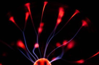 Kırmızı ve mavi enerji yayı ile parlayan bir plazma topu koyu bir arkaplana yayılarak canlı ve heyecan verici bir görsel efekt yaratır.