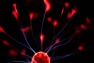 Kırmızı ve mavi enerji yayı ile parlayan bir plazma topu koyu bir arkaplana yayılarak canlı ve heyecan verici bir görsel efekt yaratır.