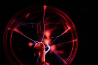 Merkezinden kırmızı ve mavi elektrik yayılan bir plazma topu, karanlık bir arka plana karşı canlı ve büyüleyici bir görsel etki yaratıyor.