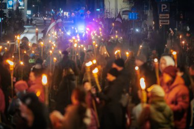 11 Kasım 'da Lpla Günü' nü kutlamak için Valmiera 'da bir meşale geçidi düzenlendi. İnsanlar ellerinde yanan meşaleler ve ulusal bayraklar tutuyor.