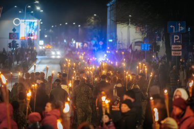 11 Kasım 'da Lpla Günü' nü kutlamak için Valmiera 'da bir meşale geçidi düzenlendi. İnsanlar ellerinde yanan meşaleler ve ulusal bayraklar tutuyor.