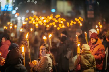 11 Kasım 'da Lpla Günü' nü kutlamak için Valmiera 'da bir meşale geçidi düzenlendi. İnsanlar ellerinde yanan meşaleler ve ulusal bayraklar tutuyor.
