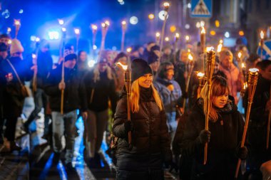 11 Kasım 'da Lpla Günü' nü kutlamak için Valmiera 'da bir meşale geçidi düzenlendi. İnsanlar ellerinde yanan meşaleler ve ulusal bayraklar tutuyor.