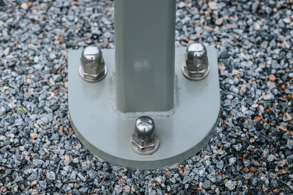 Низкоугольный вид на современный подвесный мост, демонстрирующий конструктивные балки и кабели. Мост охватывает природный ландшафт с высокими вечнозелеными деревьями и облачным небом на заднем плане.