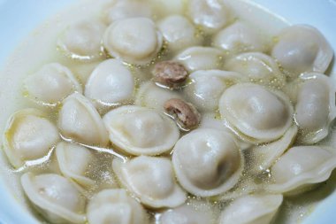 Geleneksel hamur köftelerinin yakın çekimi, yumuşak dokularını ve doyurucu dokularını gözler önüne sererek, konforlu yemek veya kültürel mutfak temaları için idealdir..