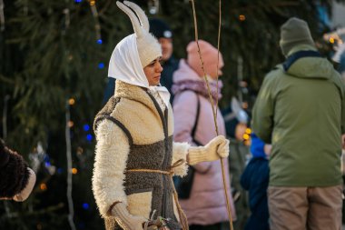 Bir grup kostümlü katılımcı, geleneksel kıyafet ve festival maskeleriyle Kış Gündönümünü kutluyor, kültürel mirası ve mevsimsel keyfi ele geçiriyorlar. 12.21.2024 Balvi, Letonya