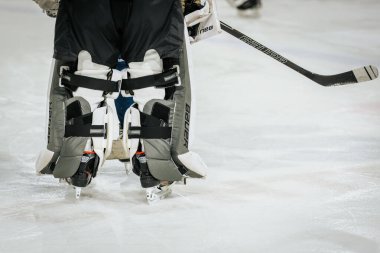 Bir grup genç buz hokeyi oyuncusunun koruyucu giysileri ve kask takıp buz pateni sahasındaki antrenman sırasında dikkatle dinlemeleri. 01.28.2025 Valmiera, Letonya