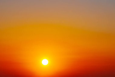 Okyanus üzerinde büyüleyici bir günbatımı, gökyüzü ve su boyunca altın ve turuncu renkler döküyor. Güneşin yansıması huzurlu ve sıcak bir atmosfer yaratır..