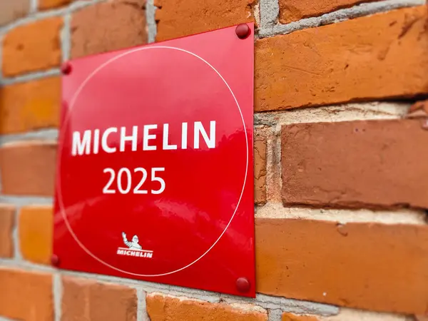Michelin 2025 plaketi tuğla duvarda, Michelin Rehberi 'ndeki restoranın tanındığını gösteriyor. Prestijli notta aşçılık mükemmelliği ve kalitesi vurgulanıyor. 02.13.2025 Ligatne, Letonya