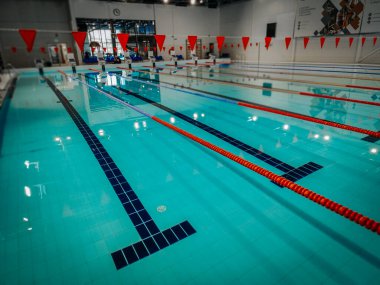 Indoor swimming pool with multiple lanes, bright lighting, and a clean design. Ideal for training, competitions, and recreational swimming in a professional sports facility