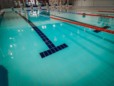 Indoor swimming pool with multiple lanes, bright lighting, and a clean design. Ideal for training, competitions, and recreational swimming in a professional sports facility