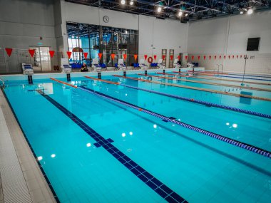  Birden fazla şeritli kapalı yüzme havuzu, parlak ışıklandırma ve temiz bir tasarım. Profesyonel bir spor tesisinde eğitim, yarışma ve eğlence amaçlı yüzme için ideal. 02.23.2025 Valmiera Latvi