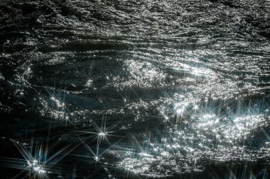 Güneş ışığı, akan suyu yansıtarak göz kamaştırıcı bir yıldız patlaması etkisi yaratır. Işıldayan ışık ve hızlı akıntılar arasındaki zıtlık sahneye dinamik ve büyüleyici bir his katar..