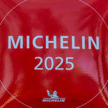 Michelin logosu ve Bibendum karakterinin yer aldığı kırmızı Michelin 2025 plaketinin yakın çekimi Michelin Rehberi tarafından tanındığını gösteriyor. 04.03.2025 Valmiera, Letonya