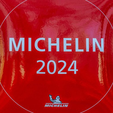 Michelin logosu ve Bibendum karakterinin yer aldığı kırmızı Michelin 2025 plaketinin yakın çekimi Michelin Rehberi tarafından tanındığını gösteriyor. 04.03.2025 Valmiera, Letonya