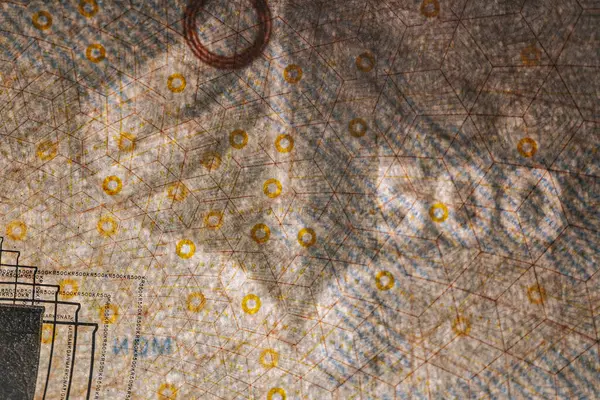 Tahta bir yüzeye yerleştirilmiş köprü çizimleri ve güvenlik unsurlarının yer aldığı Danimarka 'dan gelen 500 DKK banknotunun ayrıntılı bir görüntüsü.