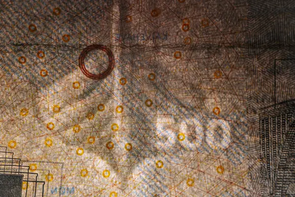 Tahta bir yüzeye yerleştirilmiş köprü çizimleri ve güvenlik unsurlarının yer aldığı Danimarka 'dan gelen 500 DKK banknotunun ayrıntılı bir görüntüsü.