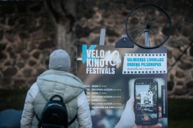 Letonya 'nın Valmiera kentindeki Velo Kino Festivalleri için bir arka ışıklandırma tabelası. Bisiklet tekeri ve parlak sokak lambaları alacakaranlıkta yıldız patlaması etkisi yaratıyor. 10.05.2025 Valmiera, Letonya