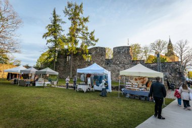 İnsanlar, el yapımı eşyalar, yerel yiyecekler ve el sanatları sunan bir açık hava pazarındaki teçhizat çadırlarının altındaki 17.05.2025 Valmiera, Letonya