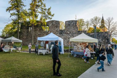 İnsanlar, el yapımı eşyalar, yerel yiyecekler ve el sanatları sunan bir açık hava pazarındaki teçhizat çadırlarının altındaki 17.05.2025 Valmiera, Letonya