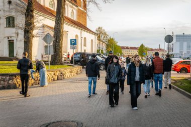 İnsanlar, el yapımı eşyalar, yerel yiyecekler ve el sanatları sunan bir açık hava pazarındaki teçhizat çadırlarının altındaki 17.05.2025 Valmiera, Letonya
