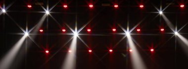 Bir sıra kırmızı LED sahne ışığı ve tek bir parlak yeşil spot ışığı karanlığı kesiyor. Dramatik ve şenlikli bir atmosfer yaratır. Kopyalama alanı dahil.