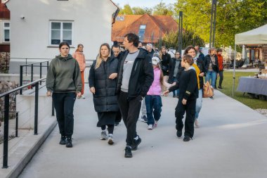 İnsanlar, el yapımı eşyalar, yerel yiyecekler ve el sanatları sunan bir açık hava pazarındaki teçhizat çadırlarının altındaki 17.05.2025 Valmiera, Letonya