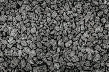 Gri tonlarda ve çeşitli boyutlarda sıkıştırılmış ezilmiş çakıl taşlarının yüksek çözünürlüklü üst görüntüsü, detaylı kaya dokusu ve doğal deseni göstermektedir..