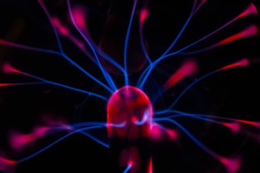 Çarpıcı bir plazma küresi, çekirdeğinden parlak mavi ve pembe elektrik yayları yayarak, karanlıkta büyüleyici ve renkli bir statik enerji gösterisi yaratır..