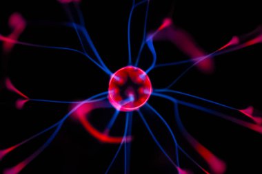 Çarpıcı bir plazma küresi, çekirdeğinden parlak mavi ve pembe elektrik yayları yayarak, karanlıkta büyüleyici ve renkli bir statik enerji gösterisi yaratır..