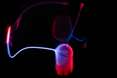 Çarpıcı bir plazma küresi, çekirdeğinden parlak mavi ve pembe elektrik yayları yayarak, karanlıkta büyüleyici ve renkli bir statik enerji gösterisi yaratır..