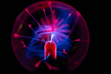 Çarpıcı bir plazma küresi, çekirdeğinden parlak mavi ve pembe elektrik yayları yayarak, karanlıkta büyüleyici ve renkli bir statik enerji gösterisi yaratır..