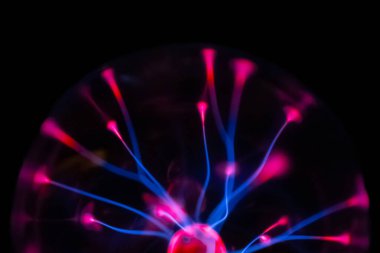 Çarpıcı bir plazma küresi, çekirdeğinden parlak mavi ve pembe elektrik yayları yayarak, karanlıkta büyüleyici ve renkli bir statik enerji gösterisi yaratır..