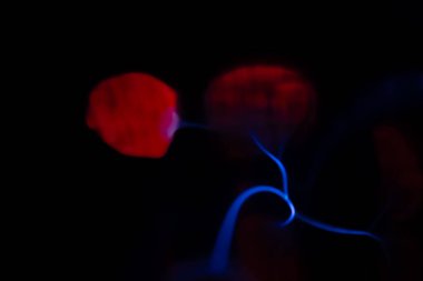 Çarpıcı bir plazma küresi, çekirdeğinden parlak mavi ve pembe elektrik yayları yayarak, karanlıkta büyüleyici ve renkli bir statik enerji gösterisi yaratır..