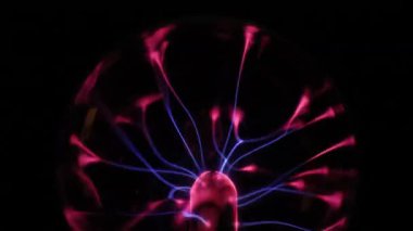 Çarpıcı bir plazma küresi, çekirdeğinden parlak mavi ve pembe elektrik yayları yayarak, karanlıkta büyüleyici ve renkli bir statik enerji gösterisi yaratır..